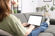 © New Africa - Woman working with laptop on sofa indoors, closeup. Mockup for design