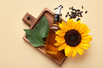 Wall Mural - Bottle of oil with sunflower, leaves and seeds on beige background