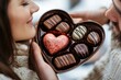 © sunshinemother - A heart shaped box of chocolates is offered and received between two people.