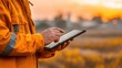 © Oulaphone - A worker uses a tablet to take GPS readings of a field boundary for precision agriculture and land management.