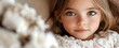 © Undersea - Young Caucasian girl with bright blue eyes and light brown hair wearing white lace dress, looking directly at camera with innocent expression in soft natural light.