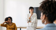 © InfinityVisuals - Professional Team in Discussion: A confident, intellectual woman leads an engaging discussion, her poised demeanor inspiring her colleagues. Together.