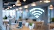 © Sergey - wifi access icon glowing above blurred busy coworking space with laptops and smartphones, symbol of internet connectivity