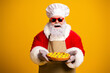 © deagreez - Jolly Santa Claus in a festive costume holding a freshly baked pie on a vibrant yellow background, smiling cheerfully