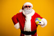 © deagreez - Santa Claus in sunglass holding a colorful volleyball on a bright yellow background, expressing holiday fun and cheer