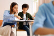 © Home-stock - Professional female teacher helping with task to Latin schoolboy, pupils sitting at desks, studying in secondary school classroom