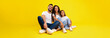 © Prostock-studio - Middle-Eastern Family Togetherness. Happy Arabic Father, Mother And Little Daughter Sitting Embracing Together And Smiling To Camera Sitting On Yellow Studio Background