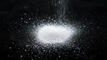 Wall Mural - A shower of sparkling silver glitter slowly descends and accumulates on a pristine black surface, revealing individual specks party, texture, contrast