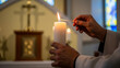 © Milan - Close-up of hands lighting a candle in a church. Religious ceremony for All Souls' Day. Concept of faith, prayer, and remembrance