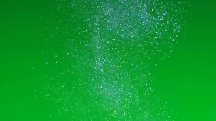 Wall Mural - Gentle slow motion rain of luminous cosmic particles falling downward through an ethereal atmosphere on a green screen light, fantasy, dreamy