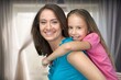 © BillionPhotos.com - cheerful small child hugging happy mother at home.