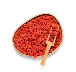 Wall Mural - Wooden plate and scoop with red dried goji berries on white background