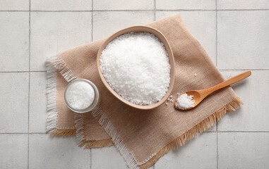 Wall Mural - Composition with bowl of sea salt, spoon and napkin on light tile background