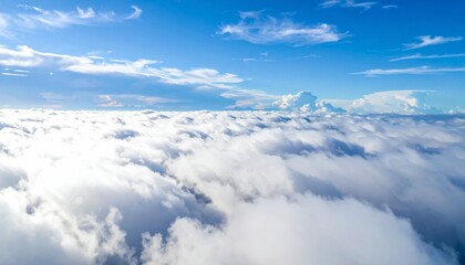 Wall Mural - High white cumulus clouds drift over the blue mountain landscape in the clear day air