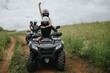 © qunica.com - A group of friends riding ATVs on a grassy off-road trail, enjoying adventure and outdoor exploration. The surrounding landscape features beautiful green fields and clear skies.