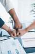 © doidam10 - Business teamwork concept with three colleagues doing fist bump in office, symbol of partnership, trust, support and successful collaboration with financial reports on desk.