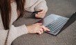 © Katrin_Primak - Woman's hand holds a credit or debit bank card while typing on a laptop for a secure online purchase