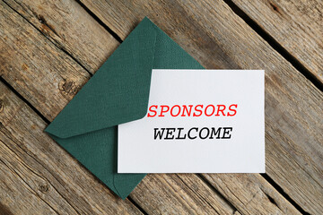 Wall Mural - Paper with phrase Sponsors Welcome and envelope on wooden background, top view