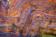 © Austockphoto - Vividly coloured and contorted rock strata in ancient layered gorge walls