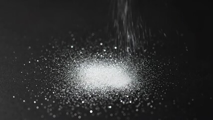 Wall Mural - A shower of sparkling silver glitter slowly descends and accumulates on a pristine black surface, revealing individual specks winter, celebration, falling
