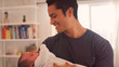 © Monkey Business - Loving Father Holding Baby Daughter Indoors At Home