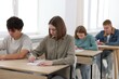 © New Africa - Students taking exam at wooden table indoors, selective focus