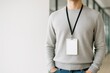 © hobonski - A man in a casual sweater wears a blank ID badge on a lanyard. Perfect mockup for modern corporate, event, or employee identification concepts.
