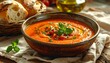 © NafiliaEmil - Close-up of gazpacho soup in ceramic bowl with sourdough bread on rustic table. Fresh ingredients, Mediterranean cuisine, and summer meal concept.