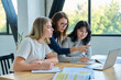 © Valerii Honcharuk - Two university student girls with female teacher mentor study while sitting at desk
