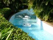© Kitz Pix - lazy river pool in tropical resort with empty tubes