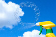 © Snide12 - Bubbles spraying from a yellow spray bottle against a bright blue sky.