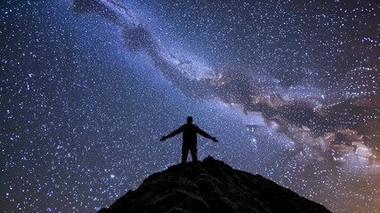 Wall Mural - Silhouette of a person on a hilltop, arms outstretched, under a starry sky. Low-angle shot captures the vastness, perfect for a cosmic-themed video. Live desktop wallpaper.