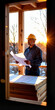 © MarGa - Thoughtful Hispanic middle-aged worker examining blueprints indoors, stacked insulation boards in soft morning light, construction concept.