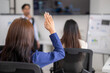 © Wasana - Businesswoman raising hand during conference meeting asking question