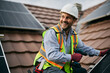 © Drazen - Happy worker mounting solar system on roof of residential building.