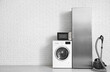 © Pixel-Shot - Different household appliances near white brick wall