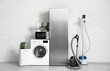 © Pixel-Shot - Different household appliances near white brick wall