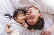 © paulaphoto - Portrait of joyful father young daughter lying close together on a bed, sharing a happy moment at home. Love father’s day