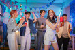 © whyframeshot - Happy office partners, men and women, joyfully celebrate Christmas and New Year together at a festive office party dancing, singing, drinking, laughing, and cheering in a warm, cheerful night of tea
