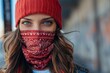 © nsit0108 - Portrait of a young woman wearing a red beanie and a scarf covering her face