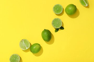 Wall Mural - Fresh ripe limes on yellow background