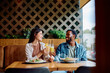 © we.bond.creations - Diverse couple enjoying a pleasant date at a restaurant, toasting with drinks and smiling happily during their dinner