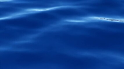 Wall Mural - Seamlessly looping video of an abstract deep blue ocean surface with slow, gentle rippling waves and reflective light, creating a serene aquatic motion serene, blue, loop