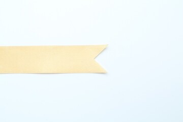 Wall Mural - Beautiful yellow ribbon on white background, top view. Space for text