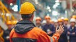© AS Studio - Industrial worker in hard hat leading safety talk for team in factory