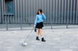 © nazariykarkhut - Young woman walking her dog in the city wearing a blue sweater and black skirt