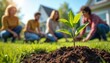 © Vadym - People plant tree seedling in backyard. Friends grow plants together outdoors at sunny day. Afforestation project helps eco system. Volunteers work to improve earth climate. Community members join