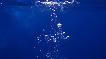 Wall Mural - Seamlessly looping video of glowing bioluminescent-like particles slowly rising through a dark, deep blue abstract liquid energy, peaceful, tranquil