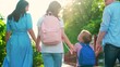 © Victoriia - Family walks hand in hand along city street in summer. School education concept children. Happy family, father mother girl boy, walks home from school together. Happy children parents on weekend walk