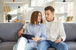 © Studio Romantic - Young couple family using tablet computer together, sitting in living room, surfing internet, shopping online, making purchases, planning new room repairing, thinking about future order, choosing